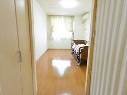 明るい居室のベッドと窓