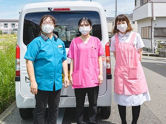 送迎車前のスタッフ  