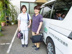 送迎車前のスタッフ2人外観  