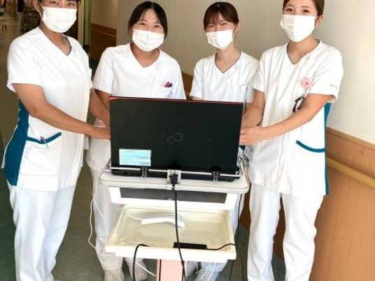 白衣のスタッフと機器の廊下  