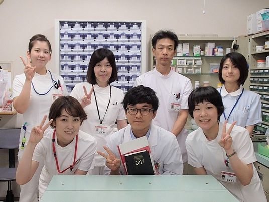 スタッフが並ぶ薬局の部屋  
