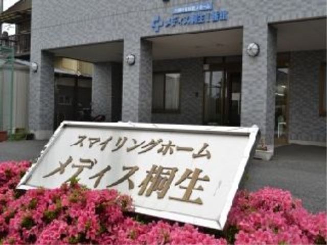 スタッフ募集の看板設置 施設 美しい花々に囲まれた看板が設置されており、穏やかな環境での勤務が想像できます。スタッフとして、温もりのある対応をしませんか。
