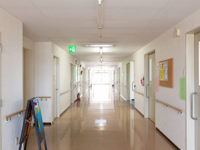 明るい廊下 通路 手すりが整備された広々とした廊下は、ゆとりをもって日々の移動ができる設計になっています。掲示物があり、コミュニケーションの場としても機能しています。
