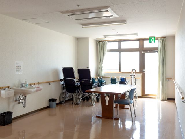 明るい多目的スペース 車椅子  広々とした空間には、ゆったりとした椅子が並び、日差しが差し込む窓際では、安心して時間を過ごすことができます。