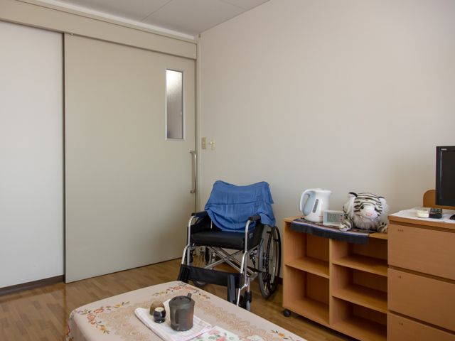 居室の一角と車椅子 居室 広々とした居室の中には、日々の生活に必要な設備が整っており、車椅子にも対応した使いやすい空間になっています。安心してご活動いただける環境です。
