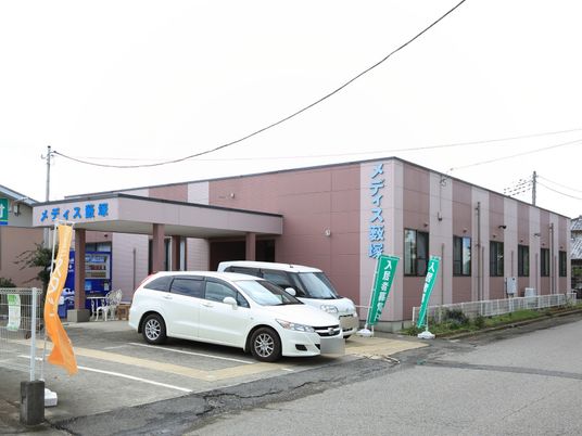 ピンクの外壁の建物エントランス