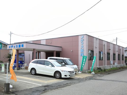 ピンクの外壁の建物エントランス