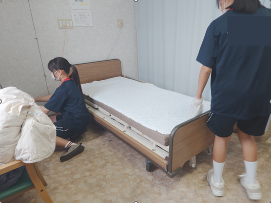 居室でベッド準備する職員  