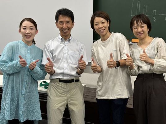 笑顔で親指を立てる4人のスタッフイメージ  