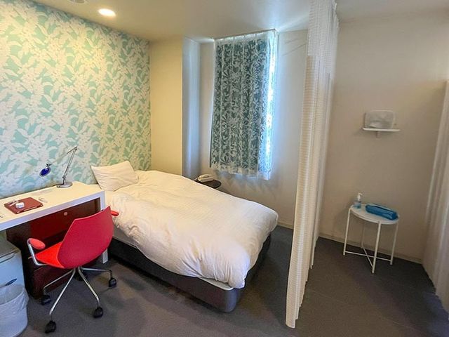 明るい個室の居室 居室   窓から光が入る落ち着いた居室です。デスクもあり、休憩や身支度がしやすい環境に見えます。