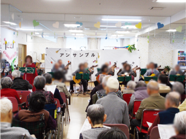 音楽会の様子ラウンジ ラウンジ 広々としたラウンジで、楽器の演奏会が開かれています。居住者がリラックスして楽しめる場です。