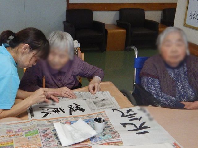書道を楽しむ様子の空間 内観   利用者が集中して書道を楽しんでいる場面です。リラックスできる時間を提供しています。