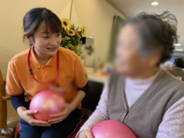 談笑するスタッフと利用者 スタッフイメージ スタッフと利用者が和やかに談笑しています。笑顔が飛び交うあたたかい雰囲気です。