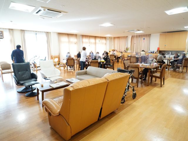 明るい共有スペース 共有スペース 広々として明るい共有ラウンジです。椅子に座って、他の方々と交流を楽しむ姿が見受けられます。