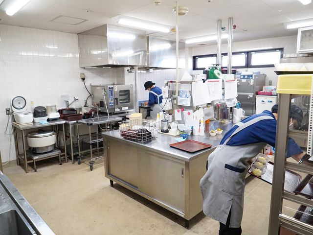 清潔なキッチン風景 キッチン スタッフが働く厨房の様子です。衛生的な環境で健康的なお食事の準備が行われています。