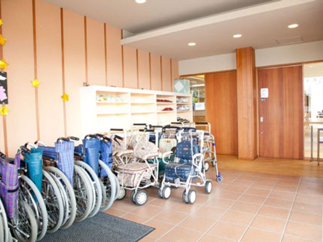 車椅子が置かれた玄関 エントランス 広々としたエントランスには、車椅子が整然と並べられ、利用者の方々にとって安心の設備が整っています。