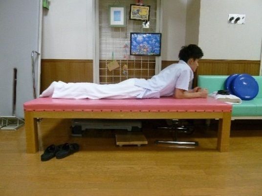 休息室でうつ伏せの男性  