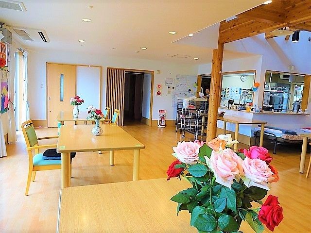 花が飾られた明るい部屋 ダイニングルーム 温かな木のテーブルと花が彩る空間で、心地よく過ごせるダイニングエリアです。