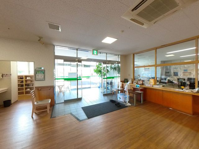 明るい共有スペース ロビー 自然光が差し込むロビーは、ゆったりとくつろげる心地よい空間です。受付での応対も行われています。