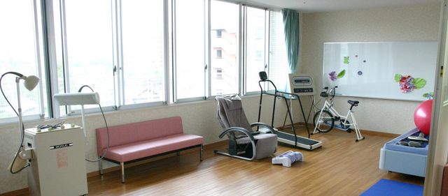 広々とした機能訓練室 機能訓練室 自然光が降り注ぐ明るい空間で、運動機器を活用したリハビリが行えます。リラックスできるソファもあります。