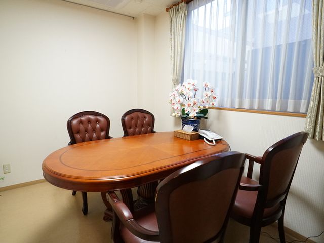 居心地の良い居室空間 共有スペース ゆったりとした会話が弾む居心地の良い部屋です。温かみのある木のテーブルが中心に置かれ、心安らぐ空間を提供しています。