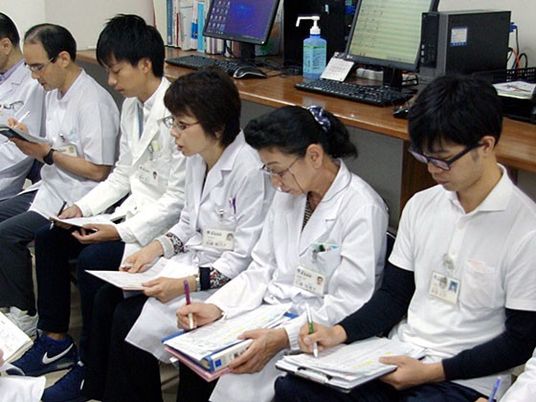 白衣で座る職員たちの休憩室  