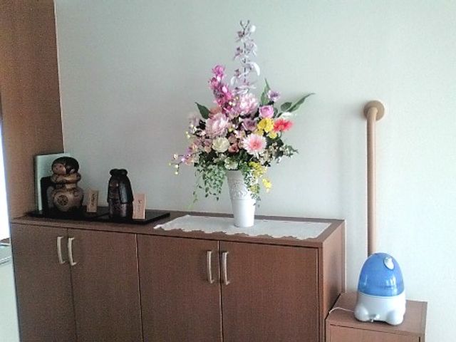 花瓶と家具のある室内 装飾品 アクセントカラーの花が飾られたシンプルな室内は、心地よい空間を演出しています。綺麗で整った環境が保たれております。