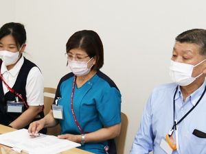 職員が並ぶ会議室  