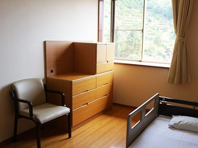 居室の椅子と収納 居室 窓から自然光が差し込む清潔感のあふれる居室です。必要な物を整理整頓できる収納家具が備えつけられています。