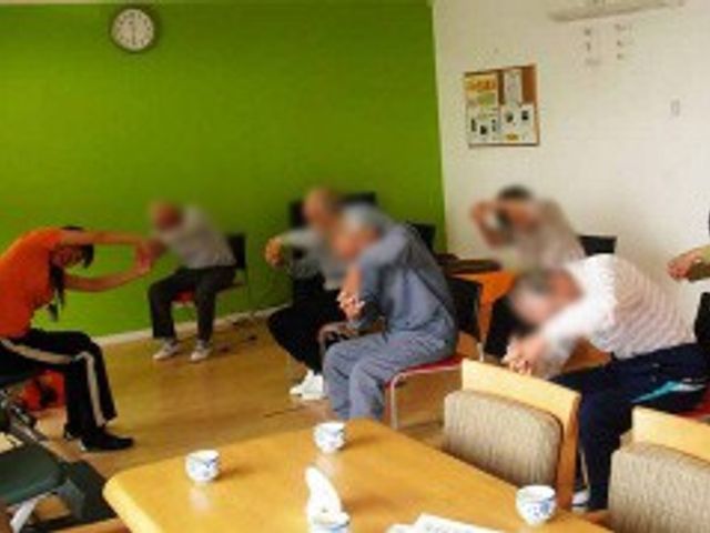 運動中の室内 機能訓練室 明るい室内で、みなさんが一緒に楽しく体操をしています。広々とした空間が魅力です。
