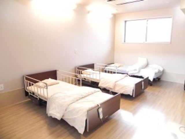 明るい相部屋の居室 居室   窓から光が入る、すっきりとした相部屋です。ベッドが並び、落ち着いて過ごしやすい空間に見えます。