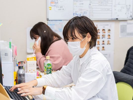 スタッフが働く事務机  
