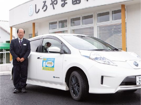 送迎車と職員の外観  