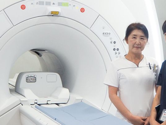 機器の前で立つスタッフ  