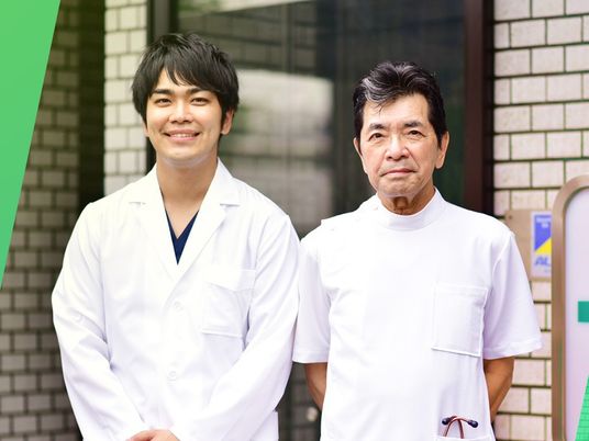 白衣の男性2人が入口に立つエントランス  