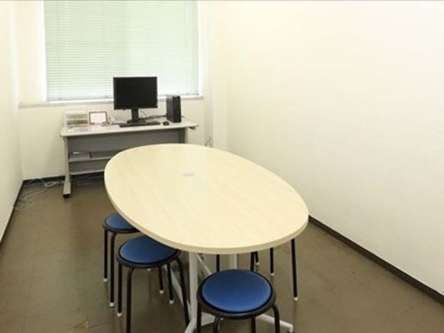 机と椅子のある多目的室 多目的室   丸い机と椅子が置かれた、すっきりした空間です。窓から光が入り、打ち合わせや作業にも使いやすそうです。