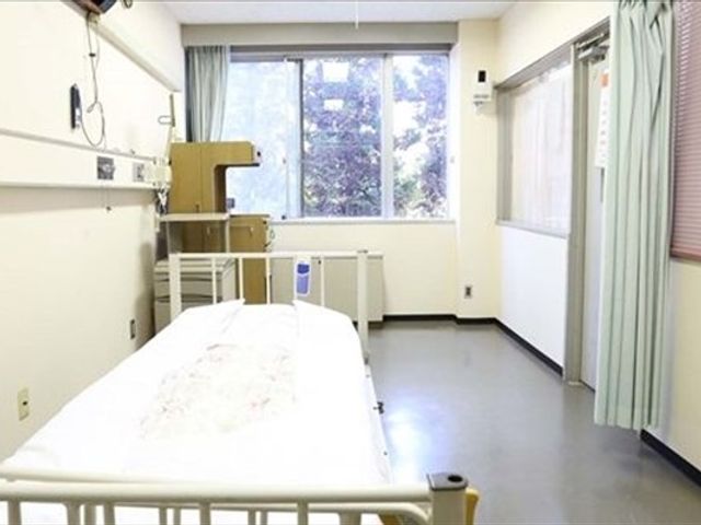 機能訓練用ベッドのある室内 機能訓練室   大きな窓から自然光が入り、明るく落ち着いた空間です。訓練用のベッドがあり、必要なケアやリハビリに使いやすそうです。