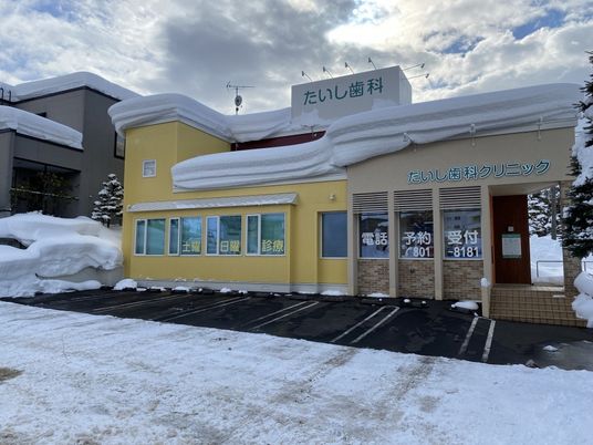 雪に覆われた歯科クリニック外観  