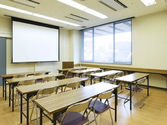 机とスクリーンのある多目的室  
