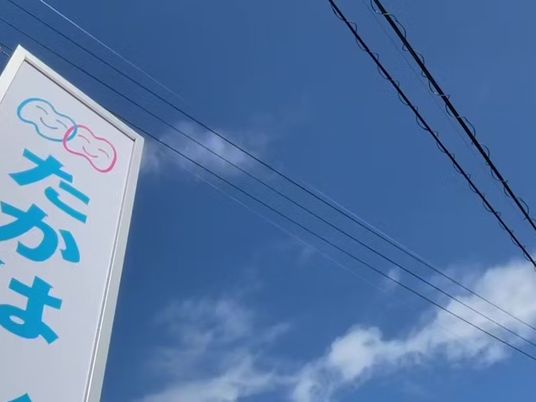 青空と看板の外観  