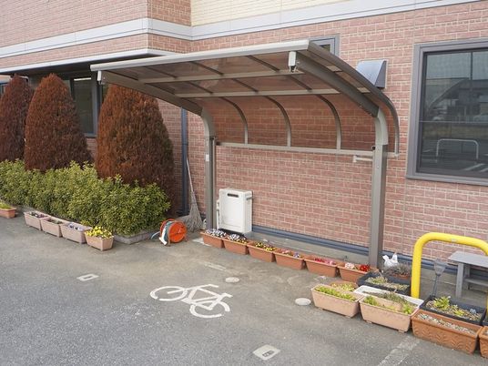 屋根付き駐輪場と花壇の外観  