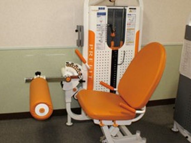 機能訓練室の運動器具 機能訓練室   明るい色の運動器具が置かれた機能訓練の場です。座ったまま使える器具もあり、体を動かしやすい環境に見えます。