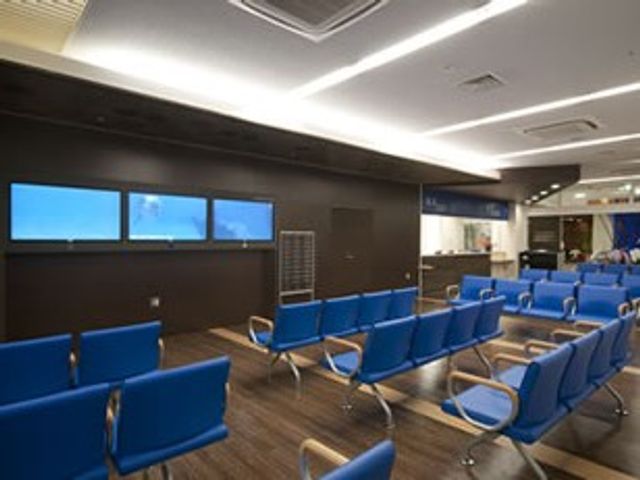 青い椅子の待合ラウンジ ラウンジ   青い椅子が並ぶ広い共有スペースです。天井の照明で全体が見やすく、来訪者対応や休憩にも使いやすそうです。
