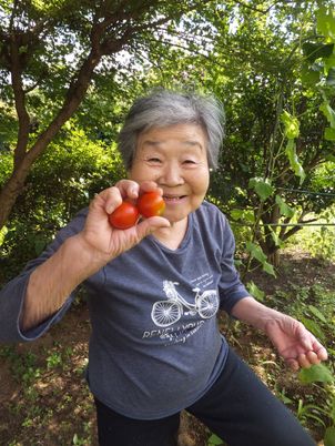 笑顔の女性とトマト中庭