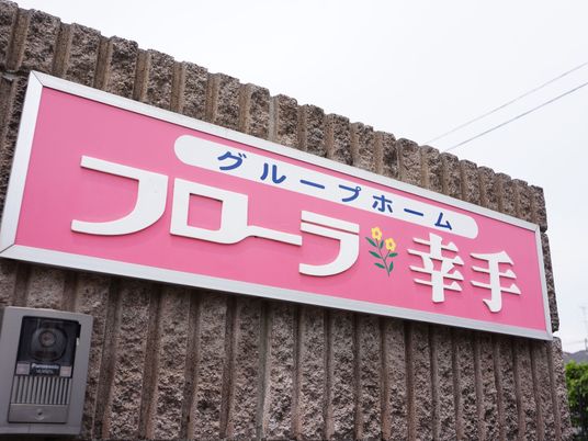 ピンクの壁に掲げられた看板