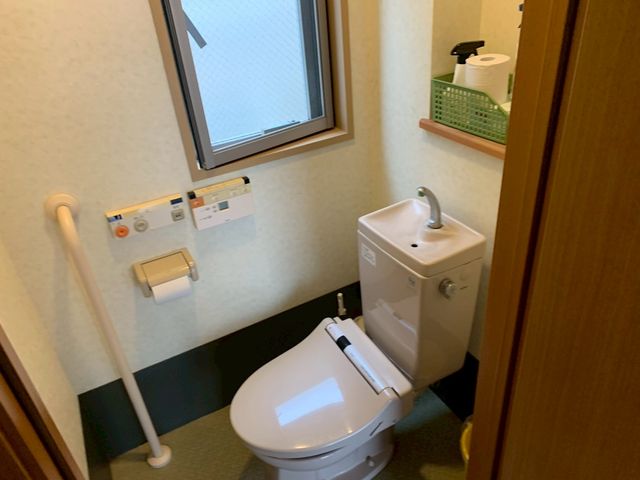 清潔な空間のトイレ トイレ 手すりが設置された快適なトイレです。自然光が差し込み、明るい空間を提供しています。