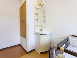 居室の洗面台とベッド