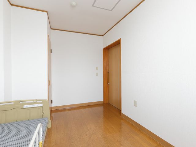 居室の木の床と白壁 居室 ゆったりとした空間の居室です。落ち着いた色合いで、快適な個人の時間を過ごせる環境が整っています。