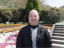笑顔の男性と彩り豊かな庭