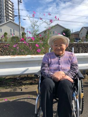 車椅子の高齢者と花
